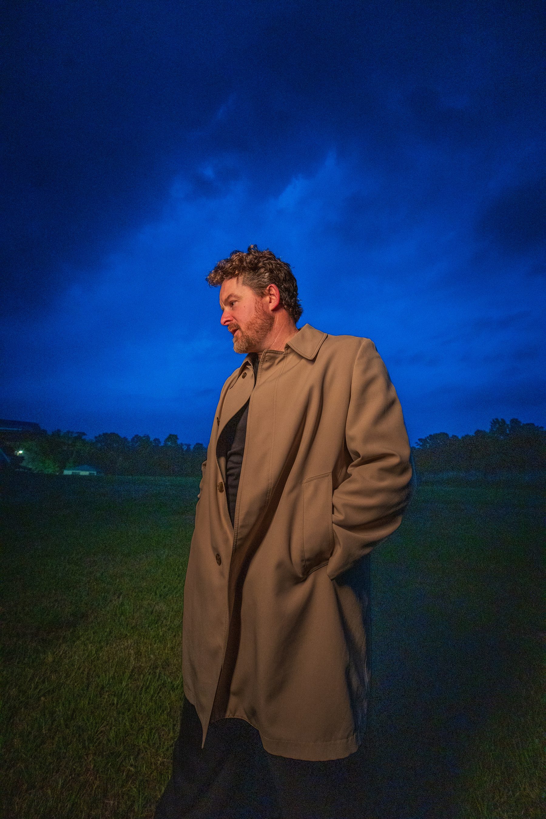 St Daylight standing in tall grass under a deep blue night sky